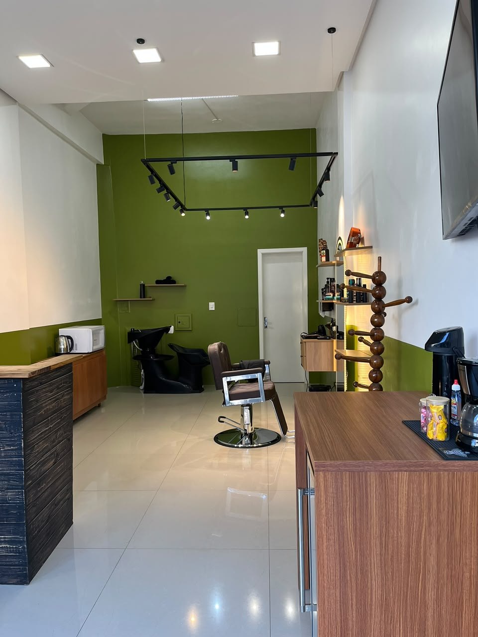Interior real da Tratto Barbearia em Marau com cadeira de barbeiro e paredes verde oliva